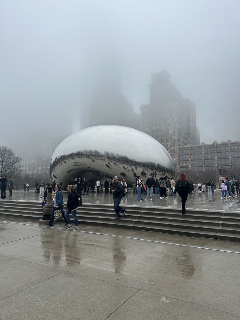 Chicago's Bean sculpture on a foggy day, the skyscrapers behind it fading into cloud.
