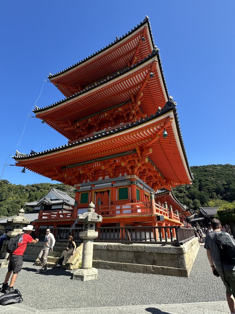 A tall red and orange pagoda against a bright blue sky.